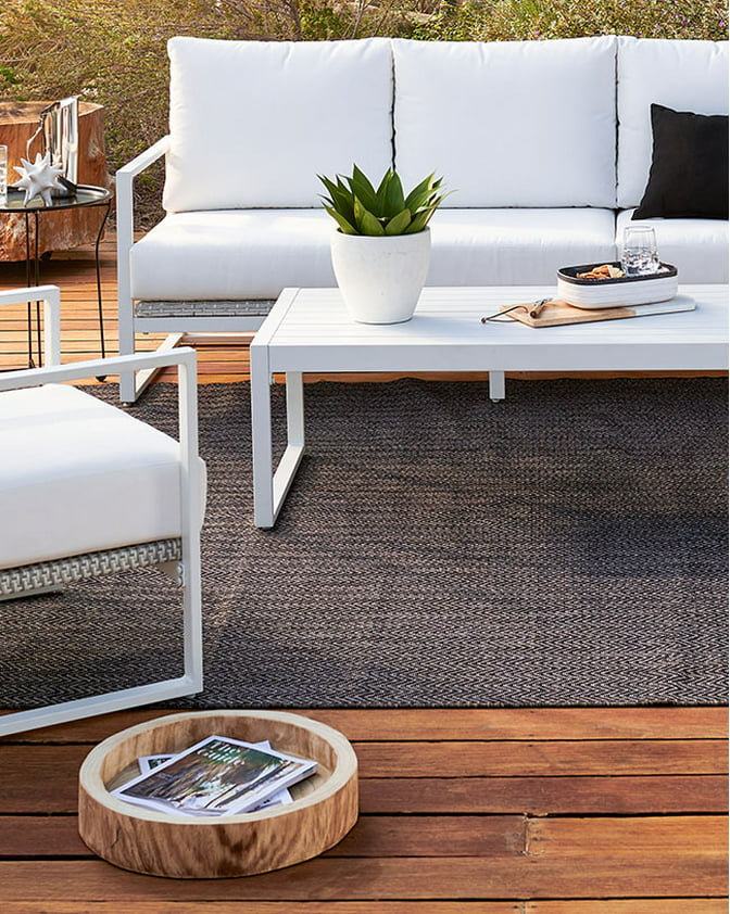 A modern white outdoor conversation set on a wooden patio. Links to patio furniture on paylessdailyonline.com.